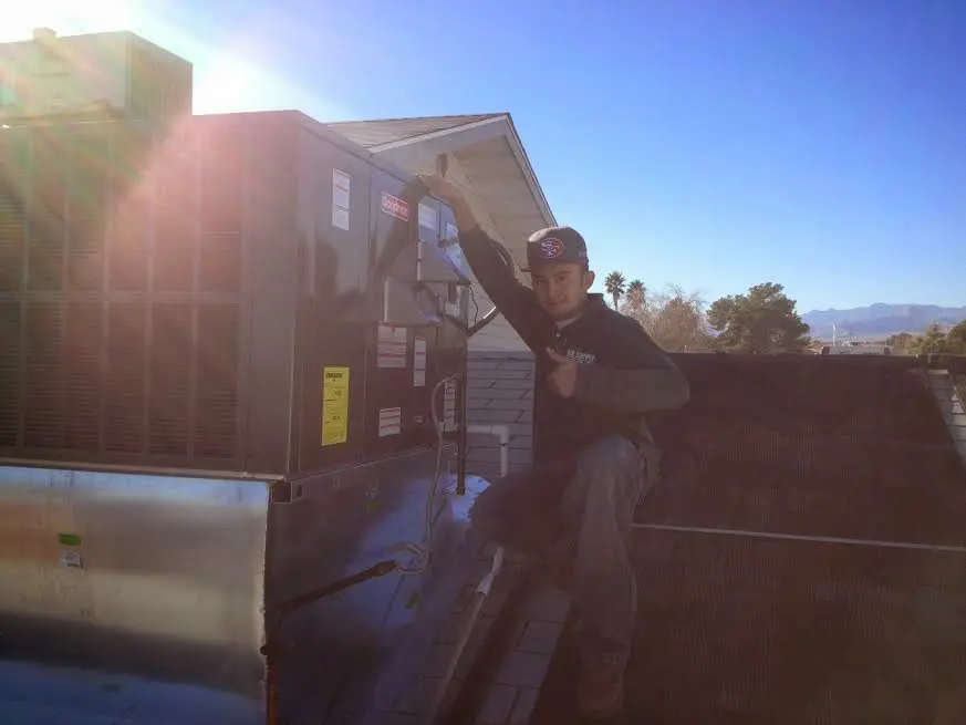 HVAC technician performing Boiler Repair on a rooftop unit in Anderson